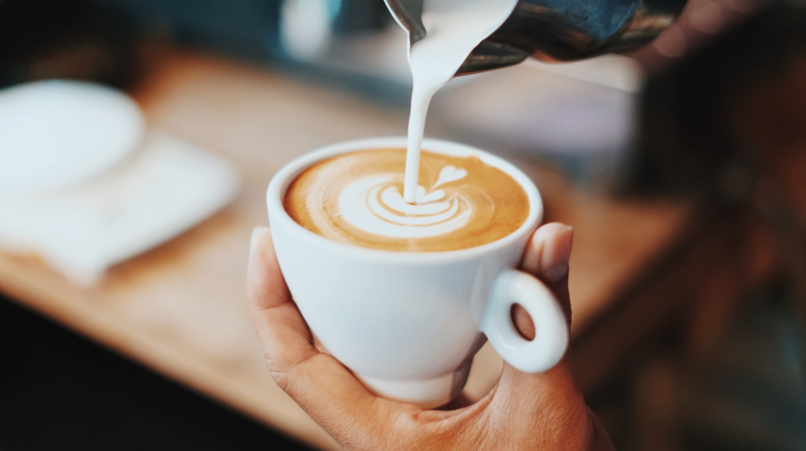 Leche cayendo sobre un espresso, dibujando el latte art